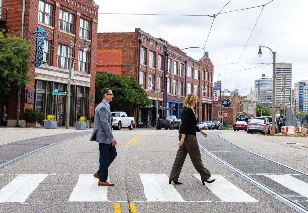 Two business professionals crossing a city street in Memphis